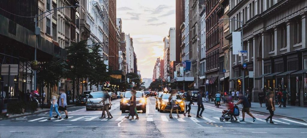 Pedestrians crossing busy city street demonstrating importance of Safe Streets For All grant program